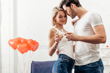 selective focus of attractive girlfriend and handsome boyfriend smiling and holding wine glasses on / Photodune, Misc