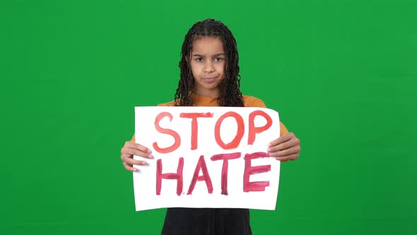 Serious African American Teen Girl Raising Stop Hate Banner Looking at Camera Shaking Head No on