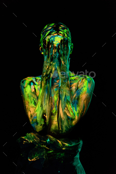 obscured view of woman painted with ultraviolet paints covering face on black backdrop / Photodune, Misc