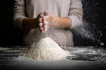 Female hands making cloud of flour. Cook clap hands with flour in the kitchen / Photodune, Misc