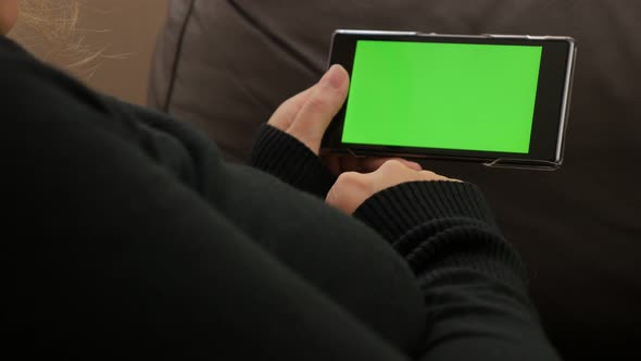 Green screen mobile phone display in woman hands 4K 2160p UHD video - Woman holding green screen sma