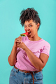 Woman eating a slice of watermelon in the form of ice cream on a turquoise background - PhotoDune Item for Sale