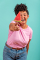 Woman eating a slice of watermelon in the form of ice cream on a turquoise background - PhotoDune Item for Sale