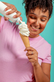 Woman eating an ice cream cone on a turquoise background - PhotoDune Item for Sale