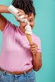 Woman eating an ice cream cone on a turquoise background - PhotoDune Item for Sale