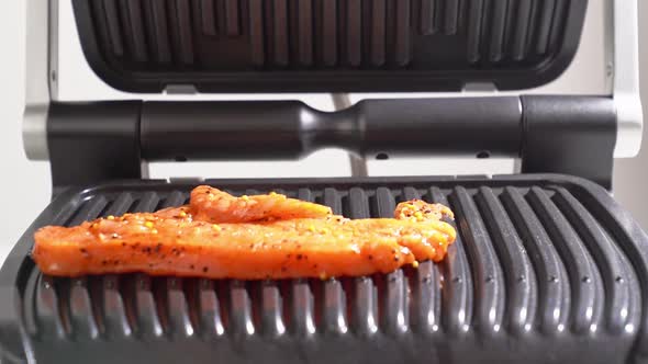 Piece of Meat Is Thrown on the Electric Grill