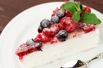 Piece of berry cheesecake served on brown wooden table / Photodune, Misc