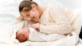 Little newborn baby and mother in wool sweater lying on bed at morning - PhotoDune Item for Sale