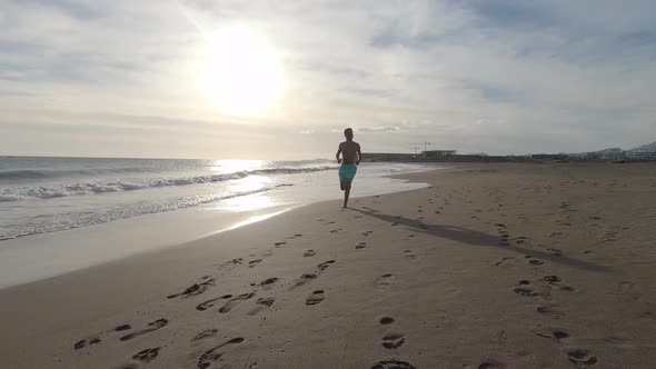 One young man running and enjoying summer in a beach alone with sunset