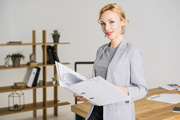 portrait of attractive businesswoman with folder in office / Photodune, Misc