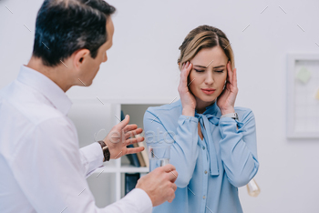 businesswoman has headache while her colleague trying to help her at office / Photodune, Misc