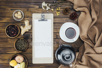 top view of blank sheet of paper on clipboard and tea set on wooden table / Photodune, Misc