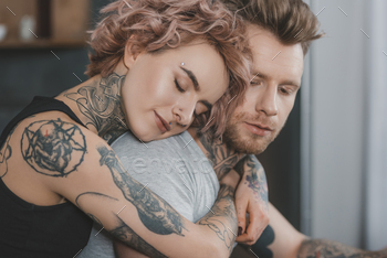 young tattooed couple hugging with closed eyes / Photodune, Misc