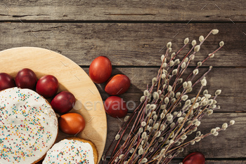 top view of painted chicken eggs, easter cakes and catkins on wooden surface / Photodune, Misc