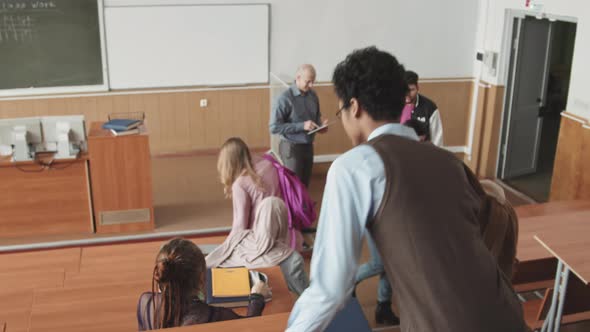 Multiethnic Students Taking their Seats in Auditorium before Lesson