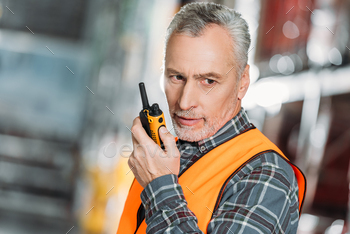 senior worker using walkie talkie in shipping stock / Photodune, Misc