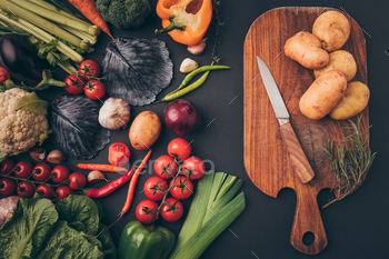 top view of ripe vegetables and wooden board on gray table / Photodune, Misc