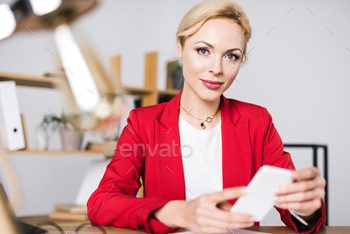 portrait of beautiful businesswoman with smartphone at workplace in office / Photodune, Misc