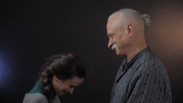 Retired Person with Grey Hair Looks at Nice Smiling Woman