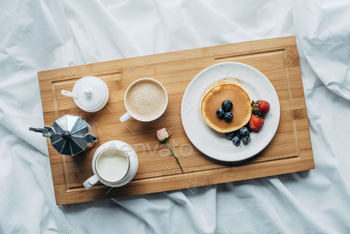top view of breakfast in bed with freshly baked pancakes and coffee on wooden tray / Photodune, Misc