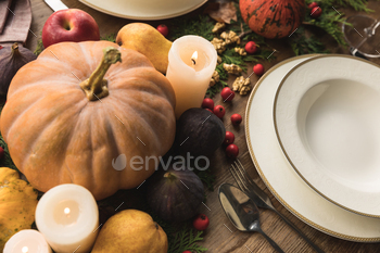 close-up view of cutlery, pumpkins, candles and fruits on table / Photodune, Misc