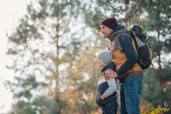 side view of father with backpack and cute little son looking away in forest / Photodune, Misc