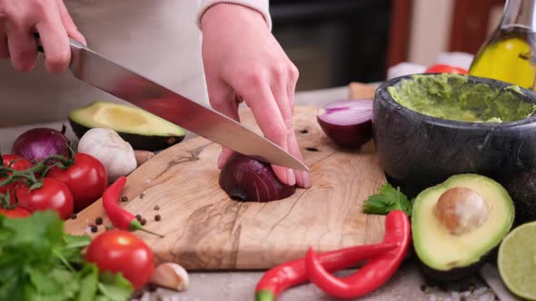 Making Guacamole Sauce  Woman Chopping Red Mars Onion on a Wooden Cutting Board