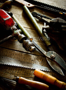 Many old working tools (drill, saw, chisel and others) on a wooden background. / Photodune, Misc