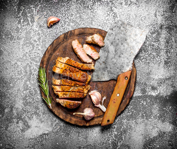 Meat grill. Sliced pork chop grilled with a hatchet for cutting. On rustic background. / Photodune, Misc