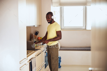 Multiracial cook watching a film on laptop while cooking / Photodune, Misc