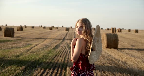 The Girl Walks Across The Field Among The Collected Sheaves Of Hay