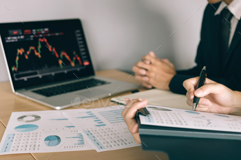 nvestors are working together with analyzing the stock data graphs in the paper / Photodune, Misc