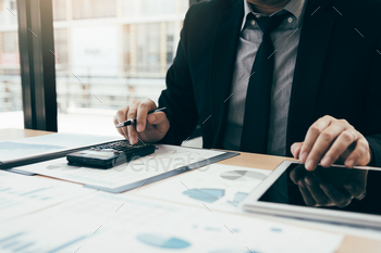 Businessmen are using calculators to calculate the company profit by deducting from expenses / Photodune, Misc