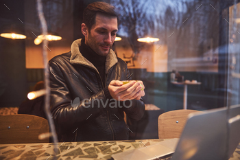 Happy man with notebook relacing with coffee in cafe / Photodune, Misc