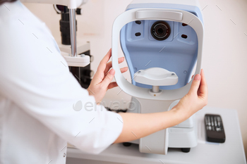 Physician putting an autorefractor rest into a right position / Photodune, Misc