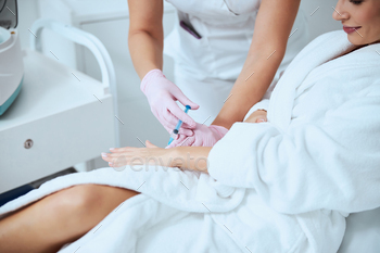 Woman client undergoing the hand rejuvenation procedure / Photodune, Misc