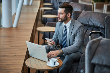 Business professional taking a smartphone while using a laptop / Photodune, Misc