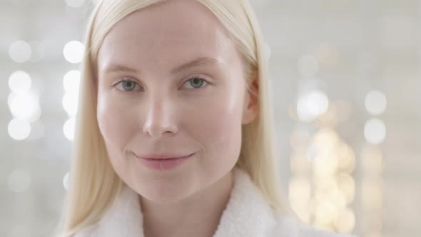 Portrait of Attractive Young Blond Woman Wearing Bathrobe With Natural Makeup Looking at Camera