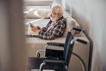 Senior man reading news on his gadget / Photodune, Misc