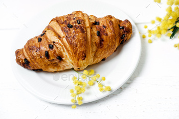 Chocolate croissant and cappuccino, decorated with mimosa flowers on a white table / Photodune, Misc