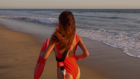 Female lifeguard running along the beach