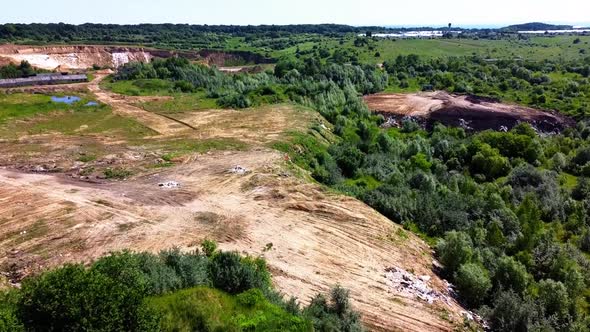 Aerial drone view of a flying over the technogenic landscape among rural agricultural fields.