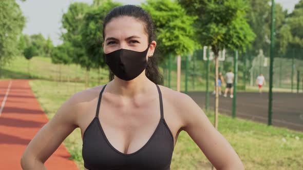 Female Jogger with a Medical Mask on the Face