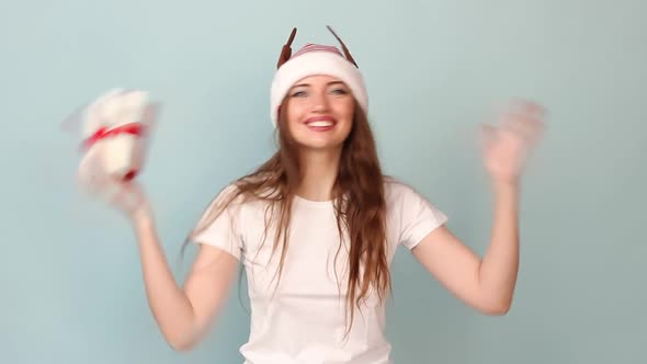 Woman White Tshirt with a Red Santa Claus Hat on a Pastel Blue Background