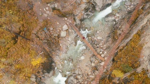 Suspension bridge in highlands Hiker at the mountain waterfall Eastern Sayan Siberia Buryatia Arshan