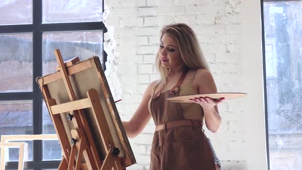 Woman Artist with Palette in Hands Creates Her Brilliant Masterpiece