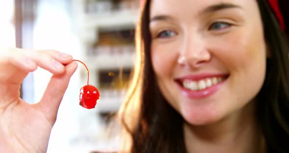 Smiling woman holding a cherry