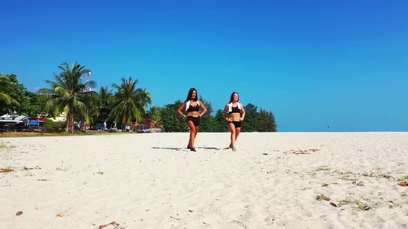 Pretty Smiling Ladies on Vacation Spending Quality Time at The Beach on Paradise White Sand and Blue