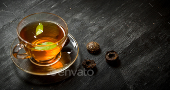 Cup of tea with green leaves. / Photodune, Misc