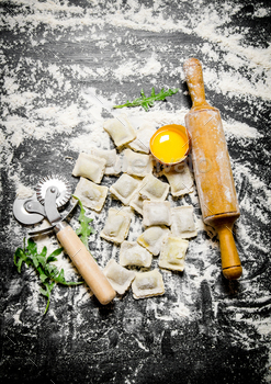 Homemade fresh ravioli with egg, a rolling pin and knife. / Photodune, Misc